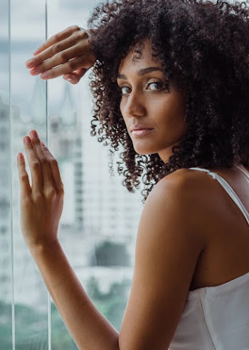 Woman Leaning on Clear Glass Wall