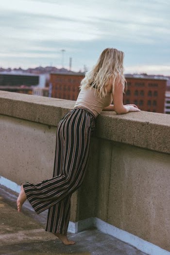 woman leaning on concrete wall