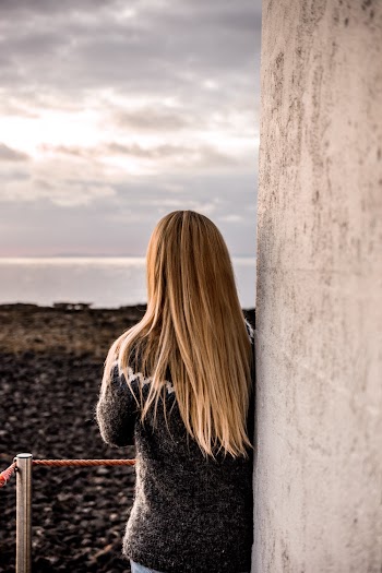Woman Leaning on Concrete Wall