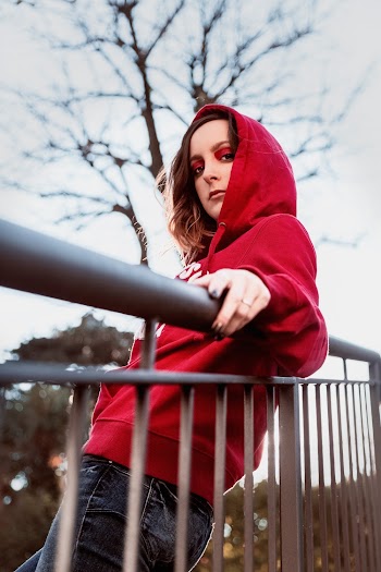 Woman Leaning on Gray Fence