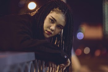 Woman Leaning on Gray Metal Railings