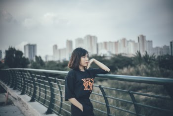 Woman Leaning on Green Metal Railing