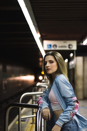 Woman Leaning on Handrail in Subway Station