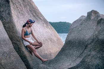 Woman Leaning on Large Rock