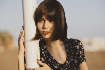 Woman Leaning on Light Post