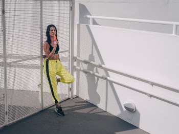 Woman Leaning On Mesh Gate While Holding Ice Pop