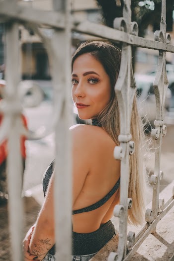 Woman Leaning On Metal Fence