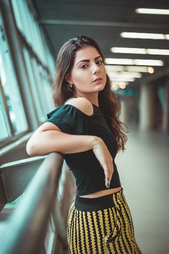Woman Leaning on Metal Grill