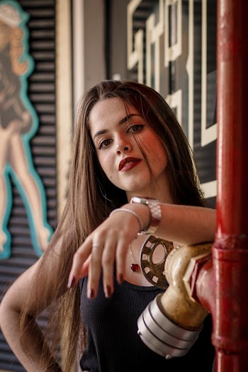 Woman Leaning On Metal Pipe