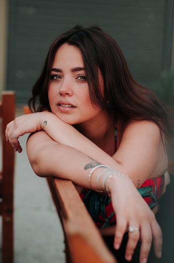 Woman Leaning on Orange Metal Bar