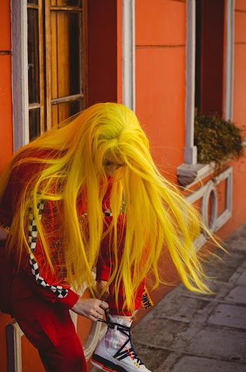 Woman Leaning on Orange Wall