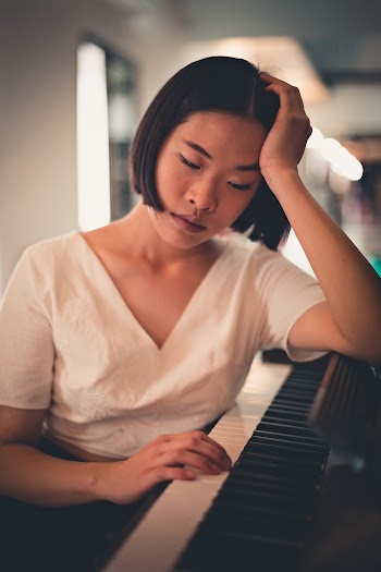 Woman Leaning On Piano