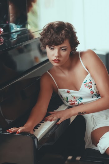 Woman Leaning on Piano Keys