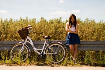 Woman Leaning on Rail Beside White Bicycle