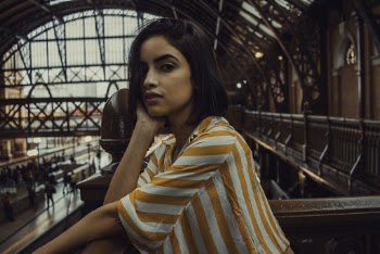 Woman Leaning on Railings in Subway Station