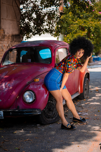 Woman Leaning on Red Volkswagen Beetle
