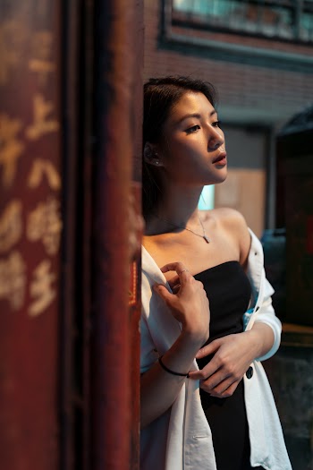 Woman Leaning on Red Wall