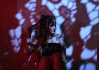 Woman Leaning on Red Wall