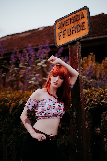 Woman Leaning on Signage Pole