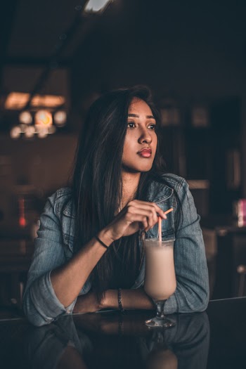 Woman Leaning on Table Having A Drink