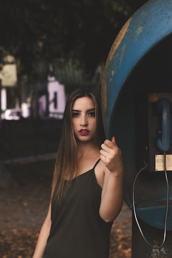 Woman Leaning on Telephone Booth