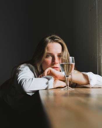 Woman Leaning on the Table and Looking at Glass of Wine  · Free Stock Photo