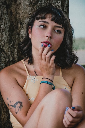 Woman Leaning on Tree Trunk