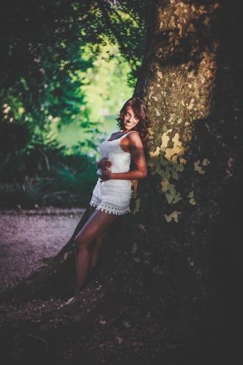 Woman Leaning On Tree While Holding Her Tummy