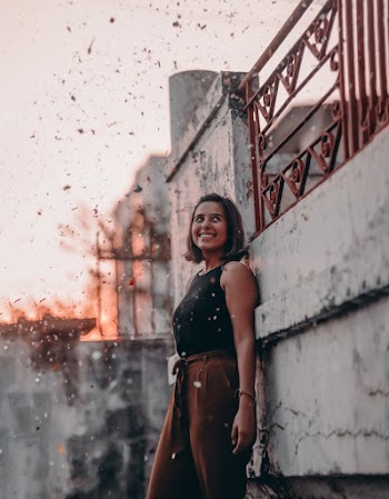 Woman Leaning on Wall While Smiling