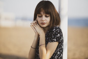 Woman Leaning on White Metal Pole