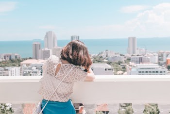 Woman Leaning on White Rail