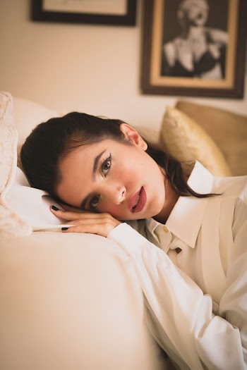 Woman Leaning on White Sofa Inside Room