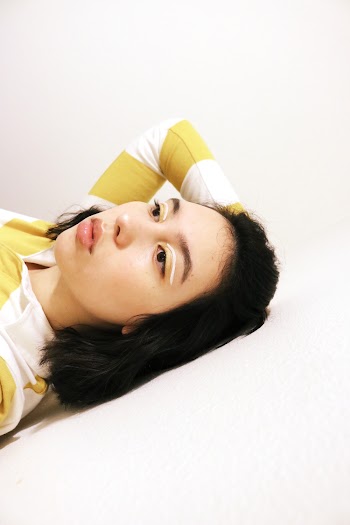 Woman Leaning on White Surface