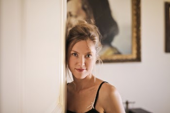 Woman Leaning on White Wall