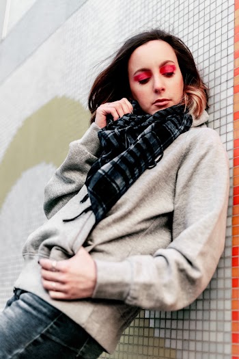 Woman Leaning on White Wall