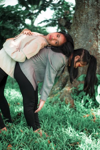 Woman Leaning on Woman's Back