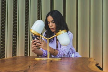 Woman Leaning on Wooden Table Using Smartphone