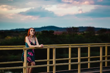 Woman Leaning on Yellow Steel Fence on Bridge