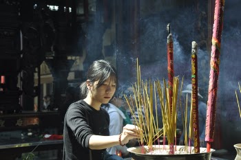 Woman Lighting Incense Sticks