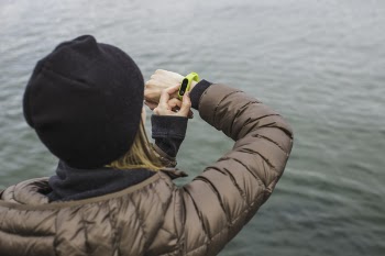 Woman Looking at Black and Yellow Activity Tracker