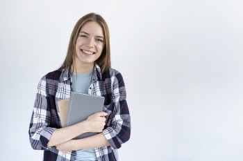 Woman looking at camera while holding some books Free Photo