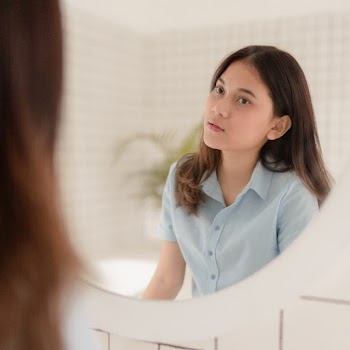 Woman Looking at Herself in the Mirror