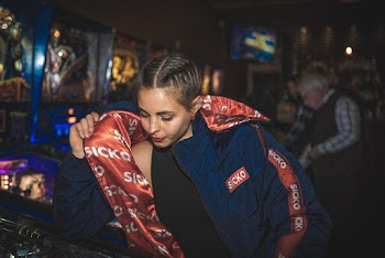 Woman Looking Down While Holding Her Blue and Red Sicko Jacket