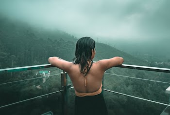 Woman Looking Out a Balcony