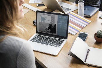 Woman Looking Side Way While Working on Laptop