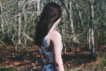 woman looking towards forest during daytime