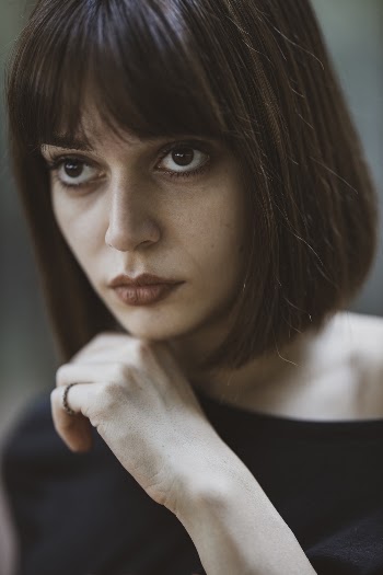 Woman Looking Up With Hand on Chin
