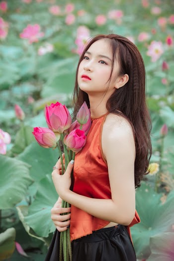 Woman Looking Upward While Holding Flowers
