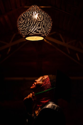 Woman Looking Upwards Toward Pendant Lamp