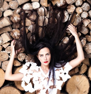 Woman Lying Down on Bunch of Logs